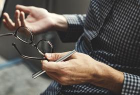 pen and glasses in male hands