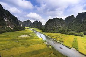 boats on ngo dong river in scenic landscape with forested rock formations, vietnam