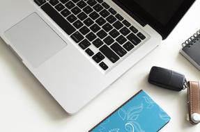 White and black laptop on the table, with other stuff