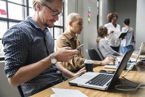 people with gadgets at work in office