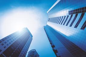 Low angle shot with the shiny skyscrapers, with the windows, under the blue sky with light