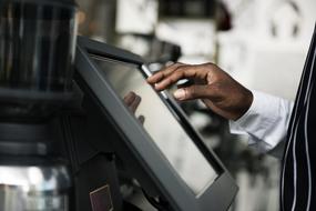 hand of african american businessman over screen in blurred background