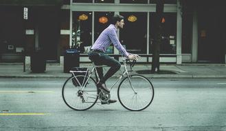 a man riding a bicycle along a city street