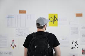 man looks at a bulletin board