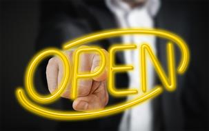 businessman points to neon yellow lettering open