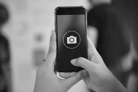 Black and white photo of the person, taking a photo on the smartphone