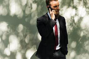 Business man with the beard is talking on the phone
