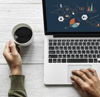 man is working on laptop with a cup of coffee