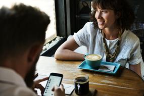 man and woman with coffee at table