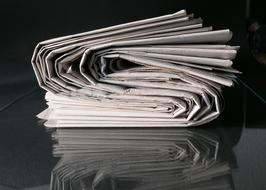 stack of newspapers on a glass table