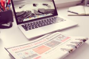 newspaper near Keyboard of laptop on desk