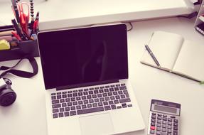 camera, laptop computer and office supplies on desk