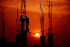 silhouettes of industrial workers at sunset