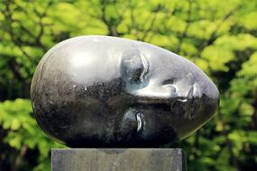 head as a statue in grand park on blurred background