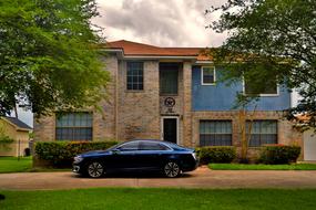 a black car stands near the mansion