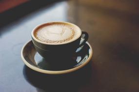 cup of hot coffee with delicate foam on a table