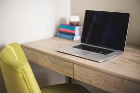 Macbook computer with black screen on desk