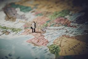 figurine of a businessman on a world map