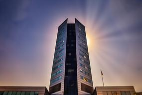Business tower with colorful Sun at background