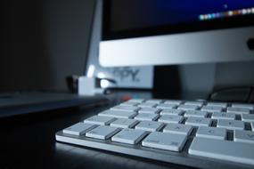 White Apple monitor and keyboard on the table