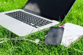 smartphone and laptop on grass