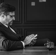 mature businessman with gadget at desk, Black And White