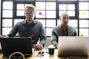 two specialists work on computers