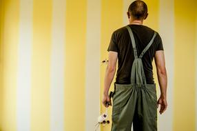 Painter at yellow striped wall