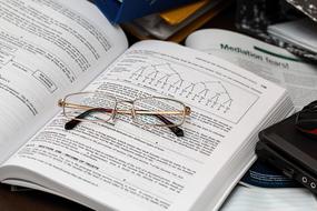 Paperwork, glasses on open book