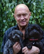 portrait of old man with two dogs in his arms