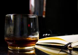 a glass of whiskey and an open diary