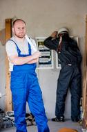 two Electrical workers at equipment