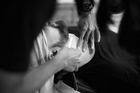 Black and white photo of shaving in barbershop