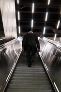 Black and white photo of the person on the escalator stairs