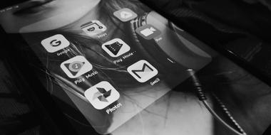 google apps icons on screen of telephone, black and white