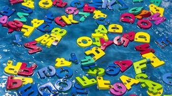 Colorful Plastic Alphabet letters at blue background