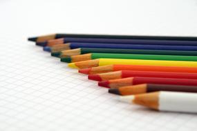 Artistic colorful pencils on the black and white checkered surface