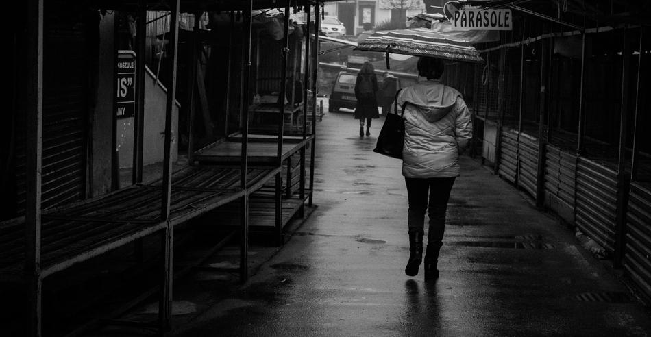 adult walking on street at rain