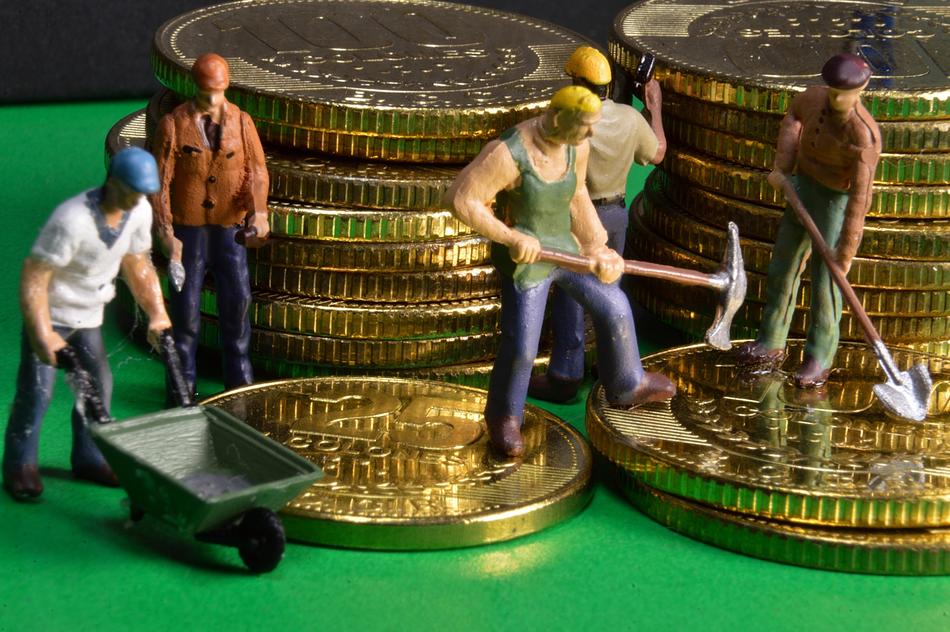 figures of workers on the background of stacks of gold coins