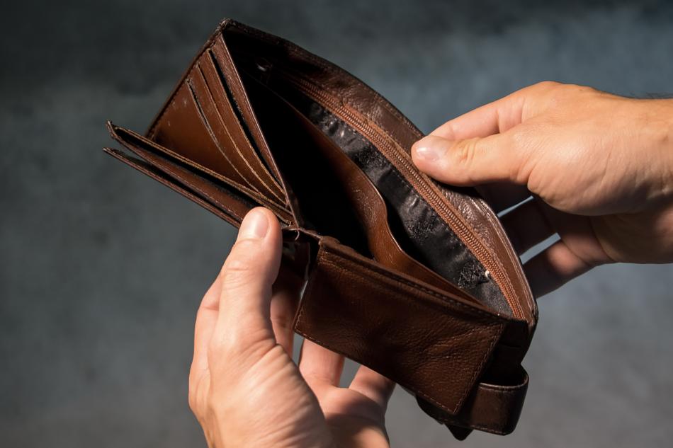Person, looking into the empty, brown purse in hands