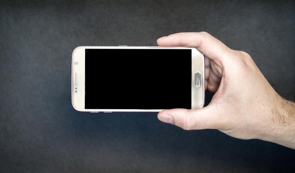 Holding the white smartphone in the hand