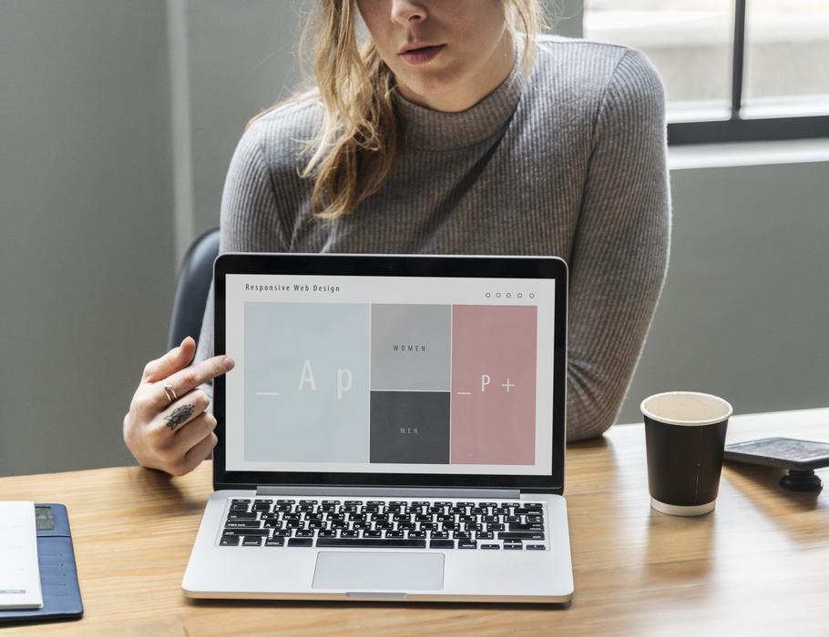 Blond girl in Casual clothe pointing to screen of laptop