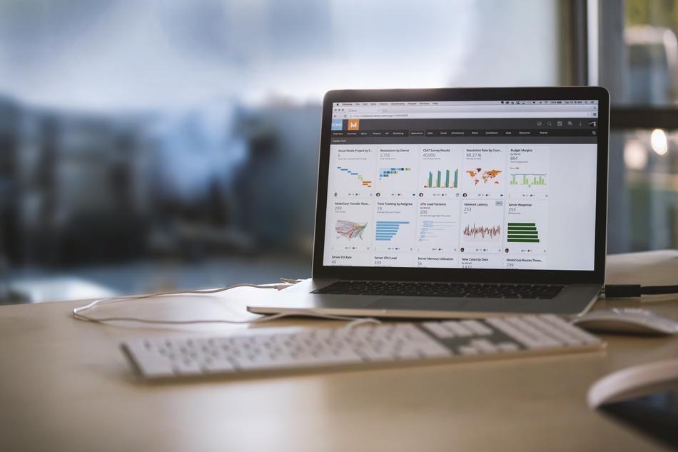 Macbook on desktop in office on blurred background