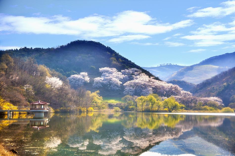 spring panorama of the reservoir against the background of blue mountains in Korea