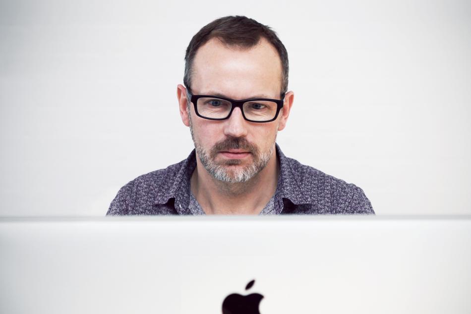 man upfront of Apple computer