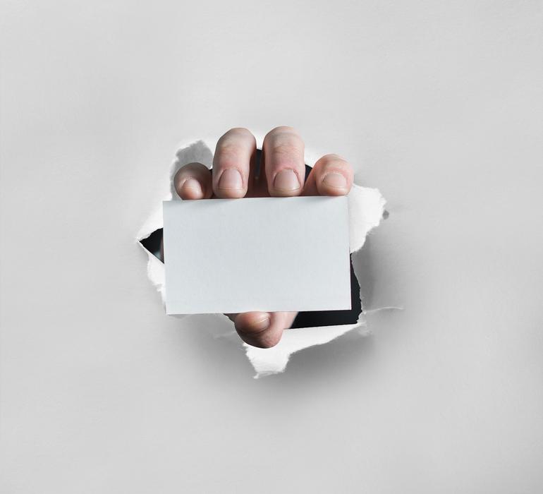 white Card in Hand on wall