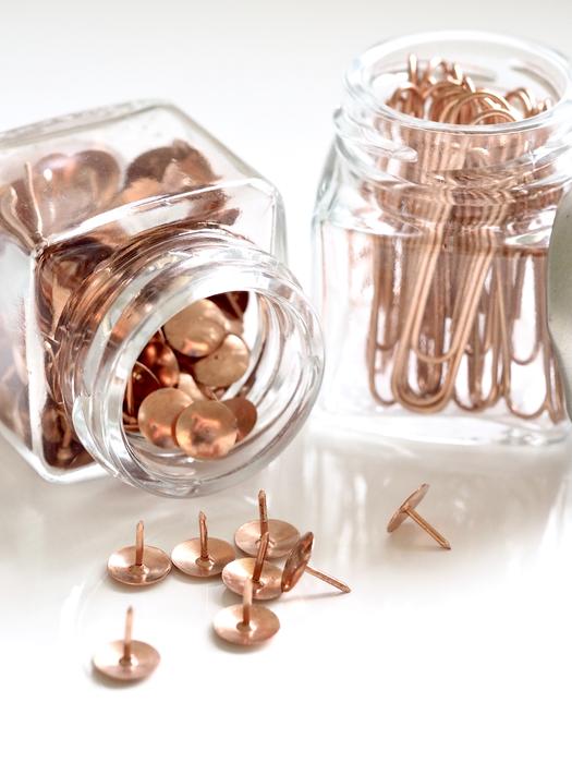 Rose gold pins and paperclips in the glass jars, in light