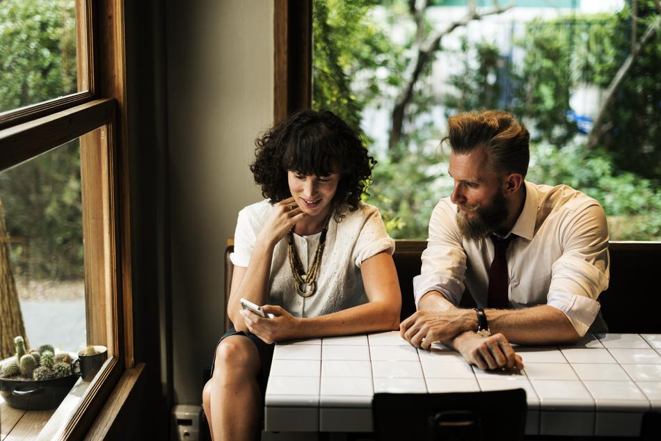 Woman and man in shirts, drinking coffee in the beautiful corner with light