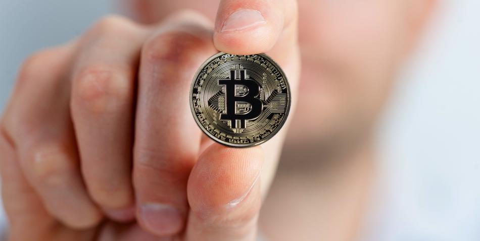 Bitcoin in hand close-up on blurred background