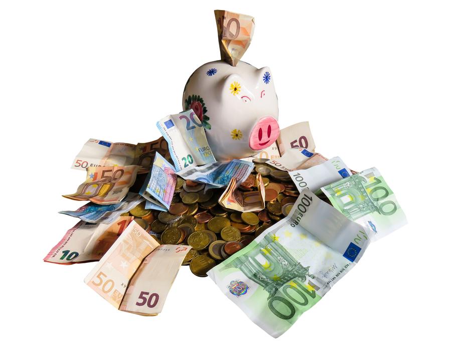 piggy bank at top of pile of cash